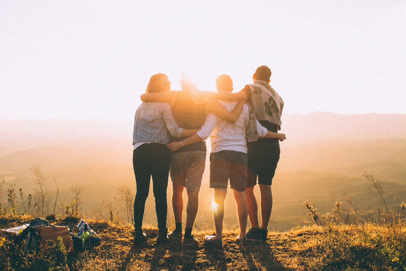 Friends arm in arm watching the sunset together — healthy and thriving